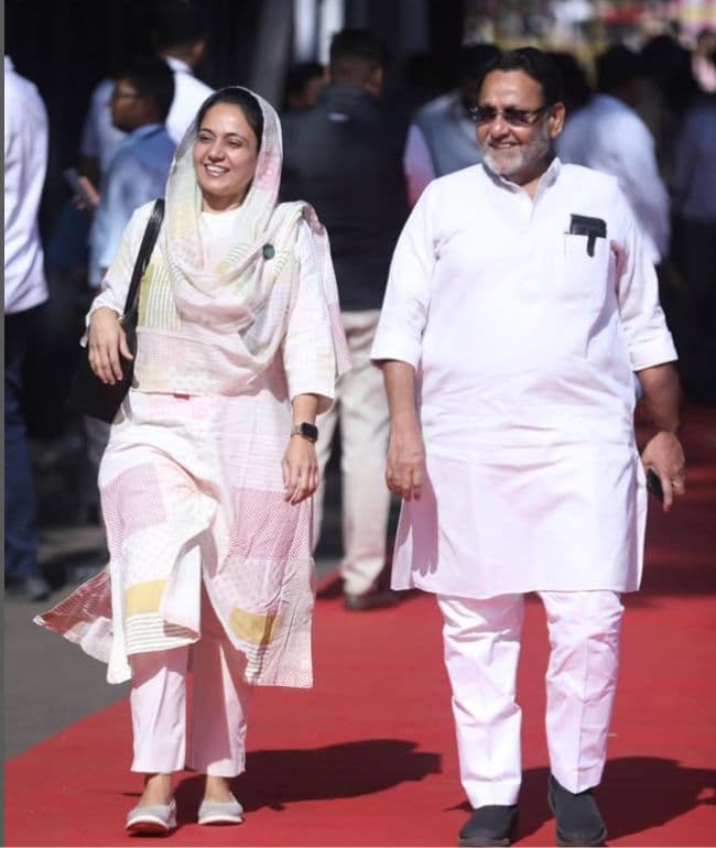 Sana Malik Shaikh walking with Nawab Malik on a red carpet